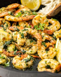 A pile of cooked garlic prawns in a skillet.