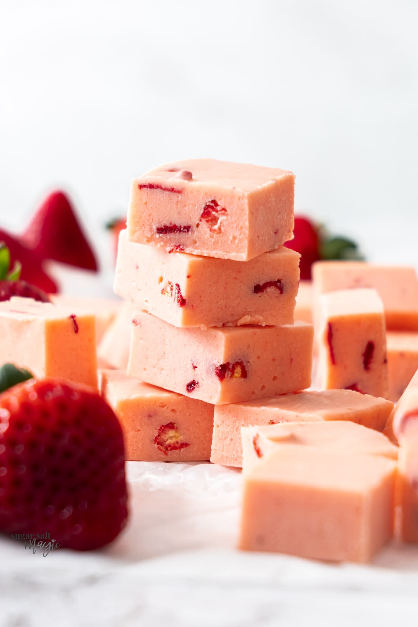 A stack of 4 pieces of strawberry fudge.
