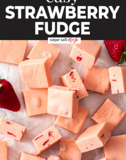 Squares of strawberry fudge on a sheet of baking paper.