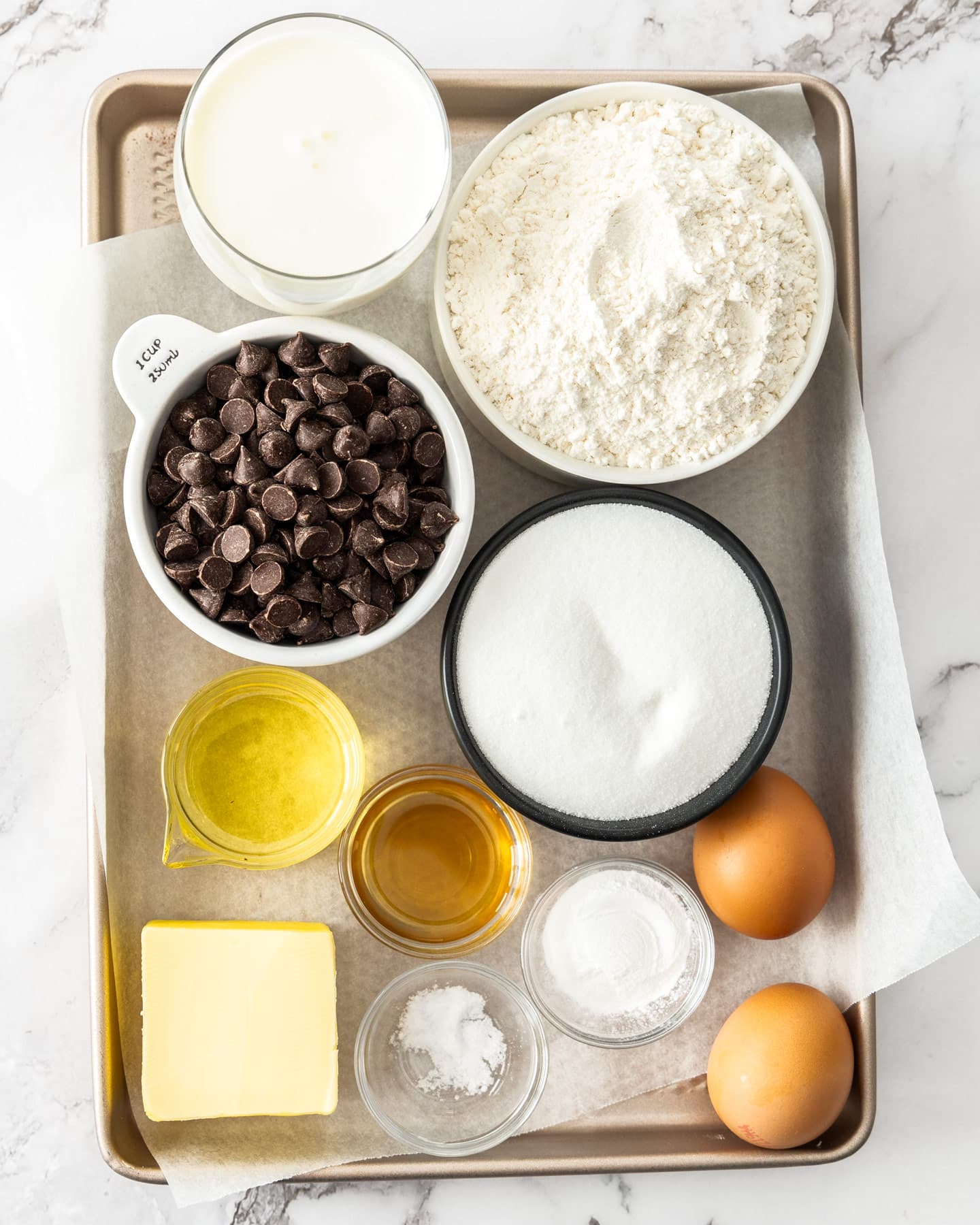 Ingredients for chocolate chip loaf cake on a baking tray.