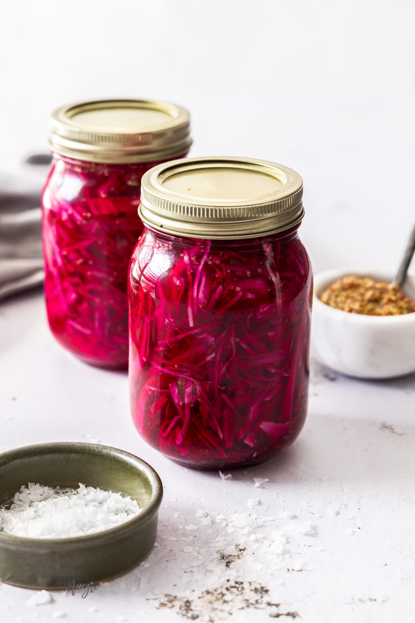 Two mason jars filled with pickled red cabbage.