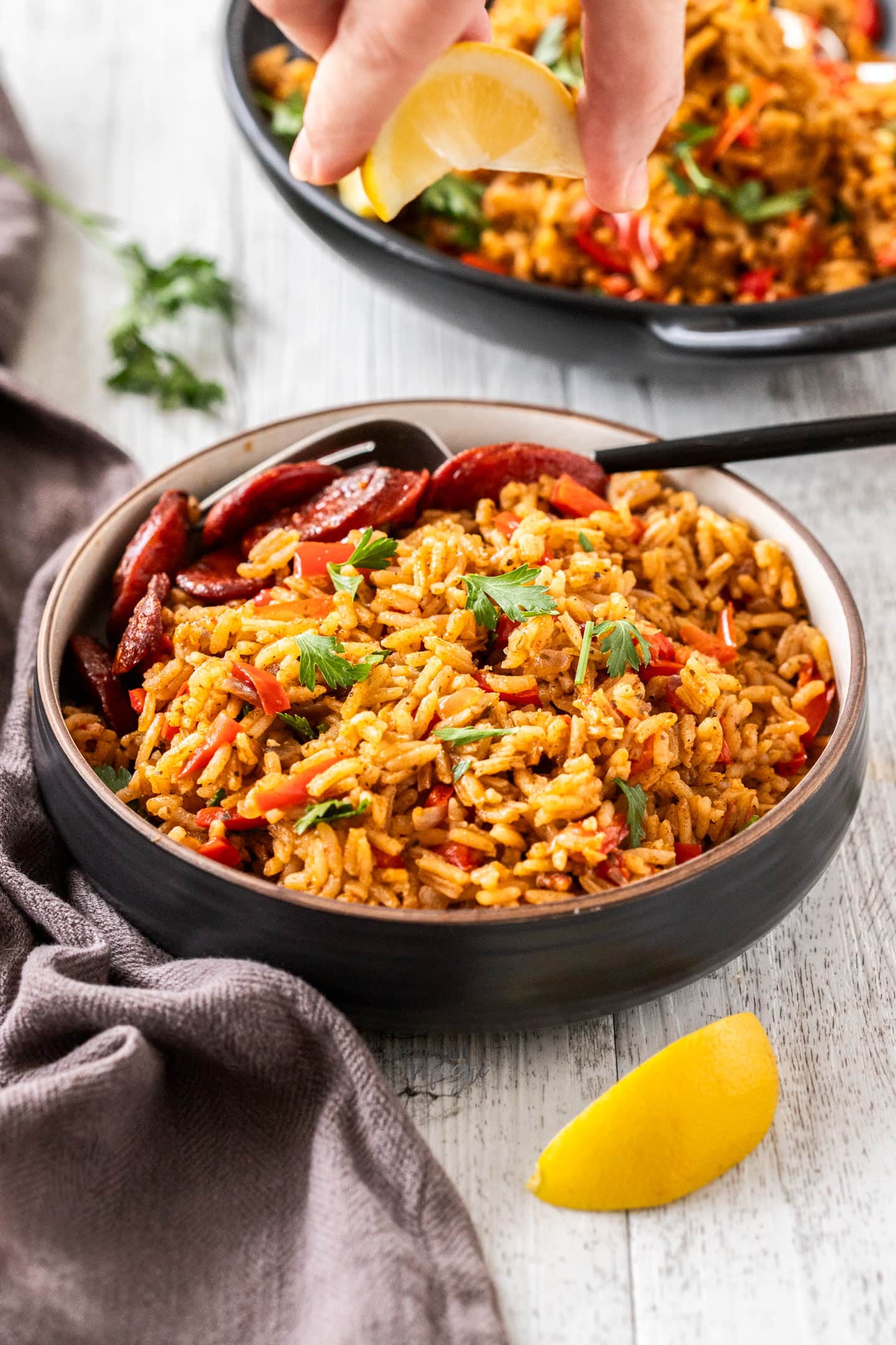 A dinner bowl filled with arroz rojo and chorizo.