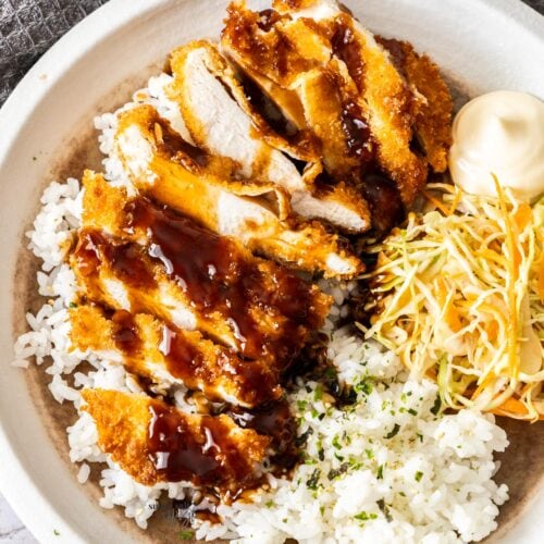 Chicken katsu with tonkatsu sauce on a plate with rice.
