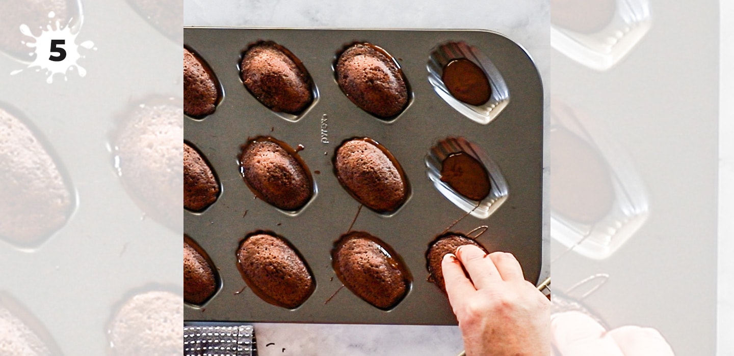 Pressing madeleines into chocolate in a mould.
