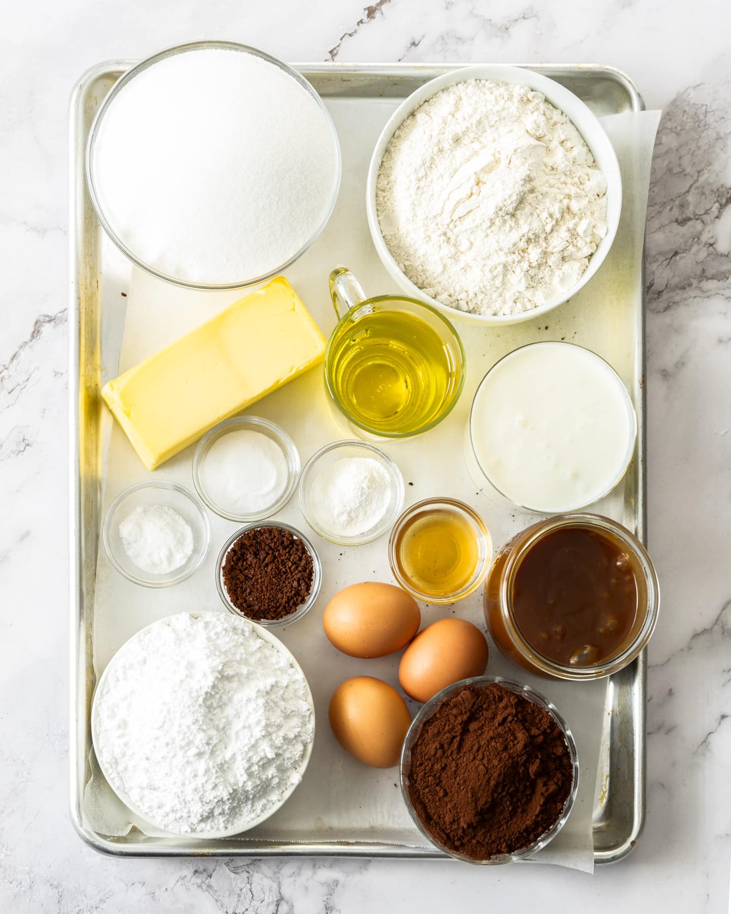 Ingredients for salted caramel chocolate cake on a baking tray.