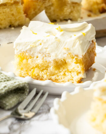 A slice of lemon poke cake on a dessert plate.