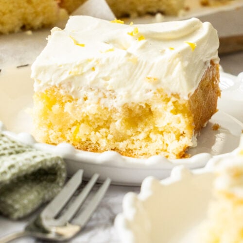 A slice of lemon poke cake on a dessert plate.