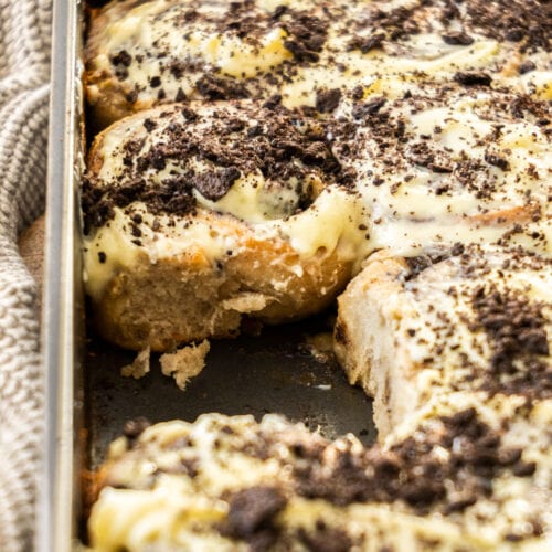 Oreo cinnamon rolls in a baking pan with one missing.