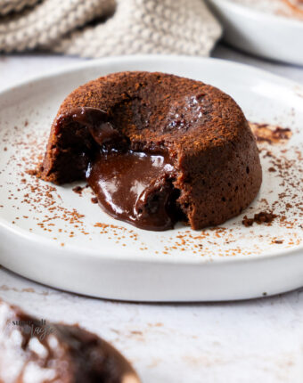 A chocolate fondant on a plate showing the gooey centre.