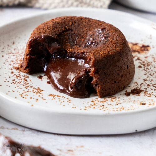 A chocolate fondant on a plate showing the gooey centre.