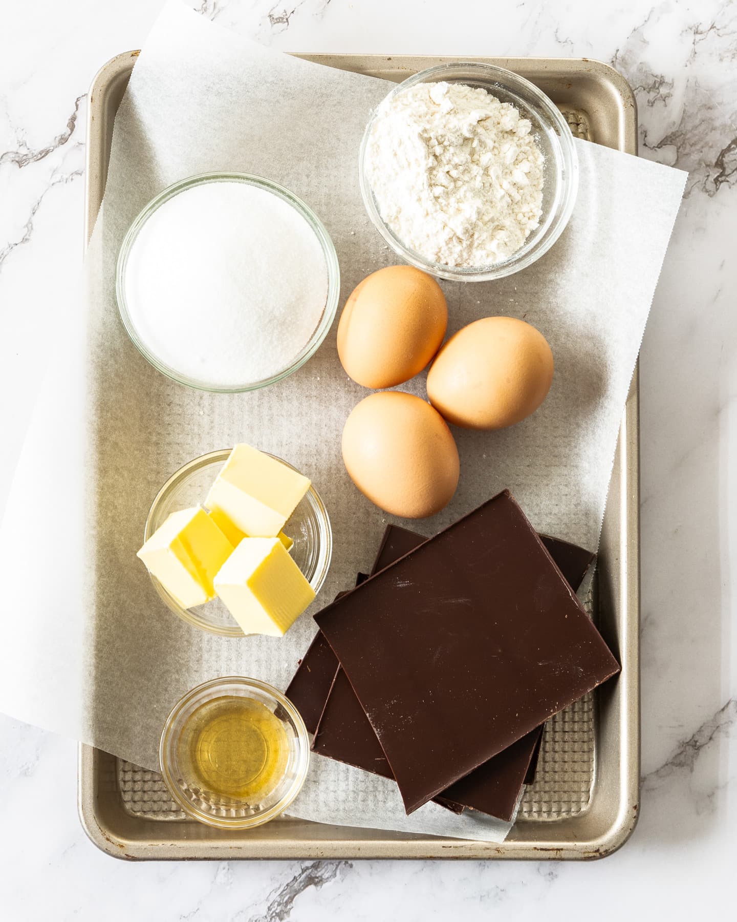 Ingredients for chocolate fondant on a baking tray.
