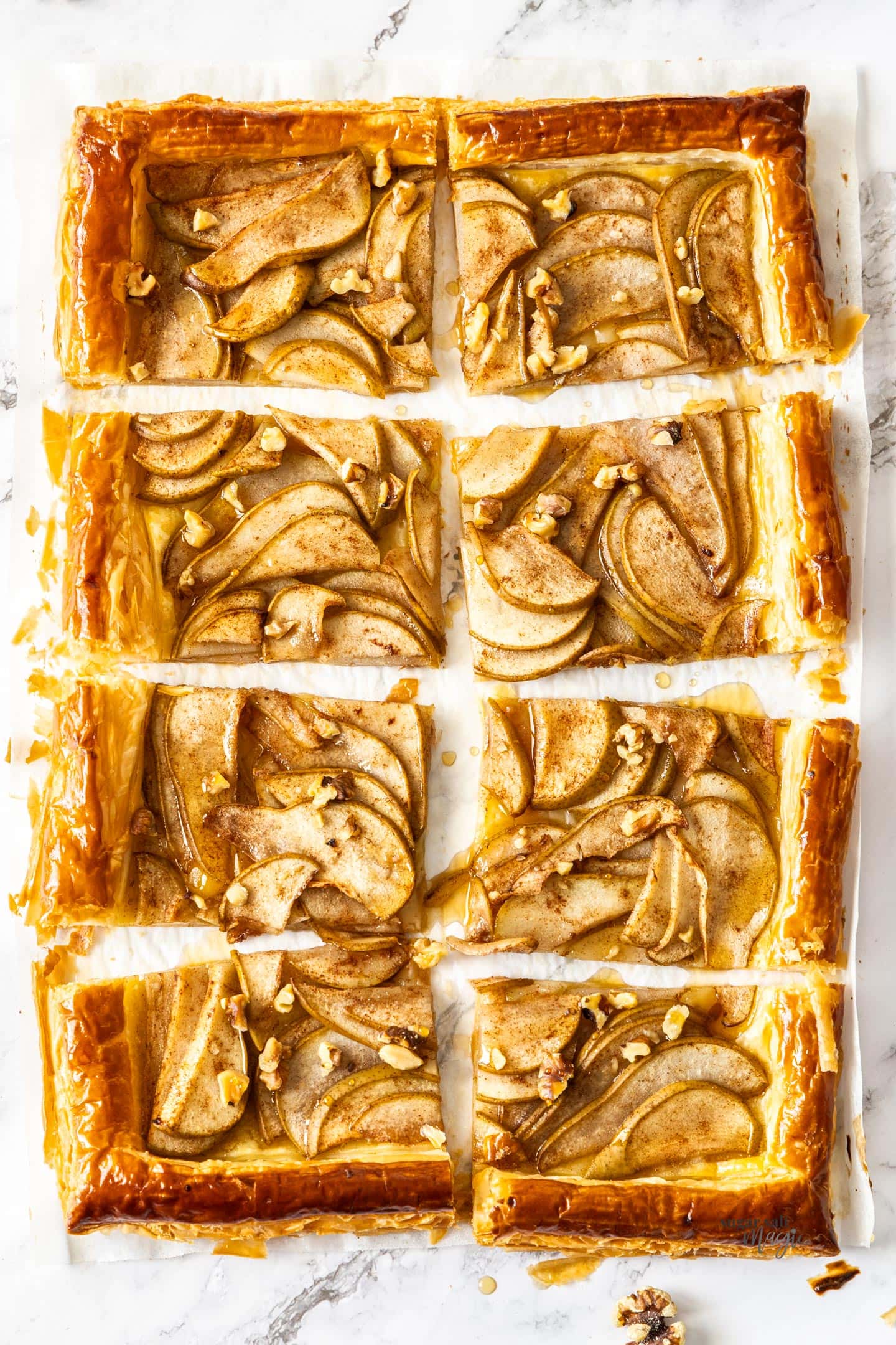 A puff pastry pear tart sliced into 8 pieces.