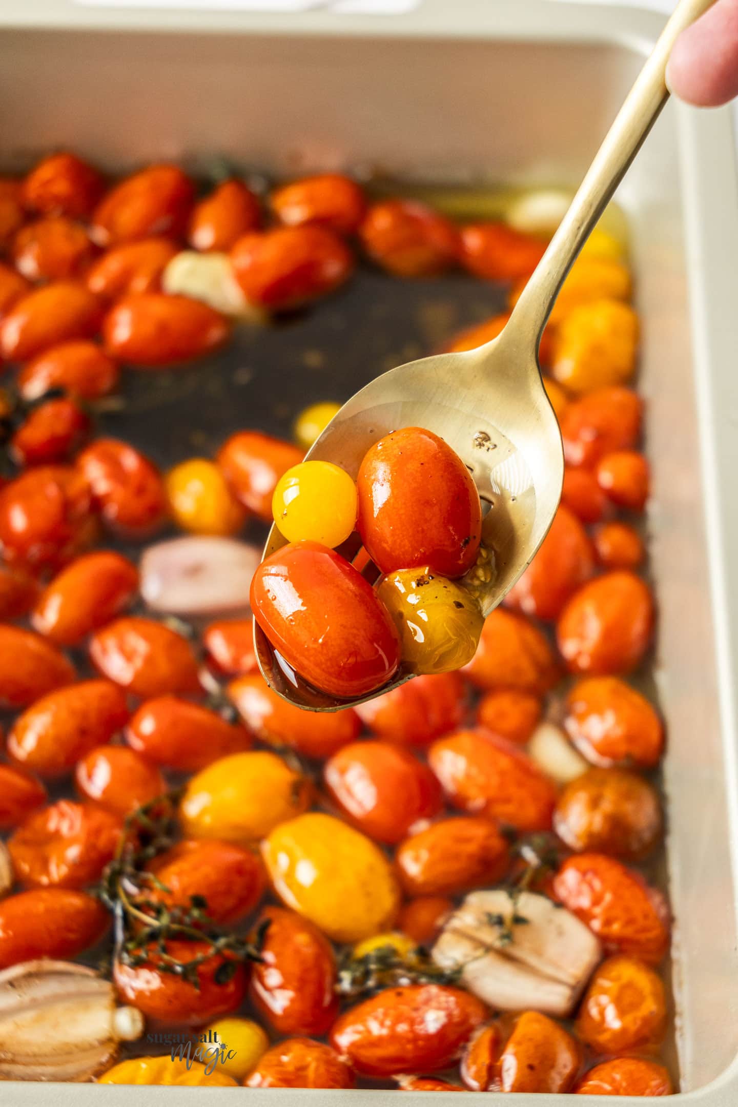 Tomatoes confit on a gold spoon.