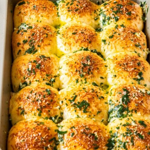 A baking tray with 15 baked dinner rolls.