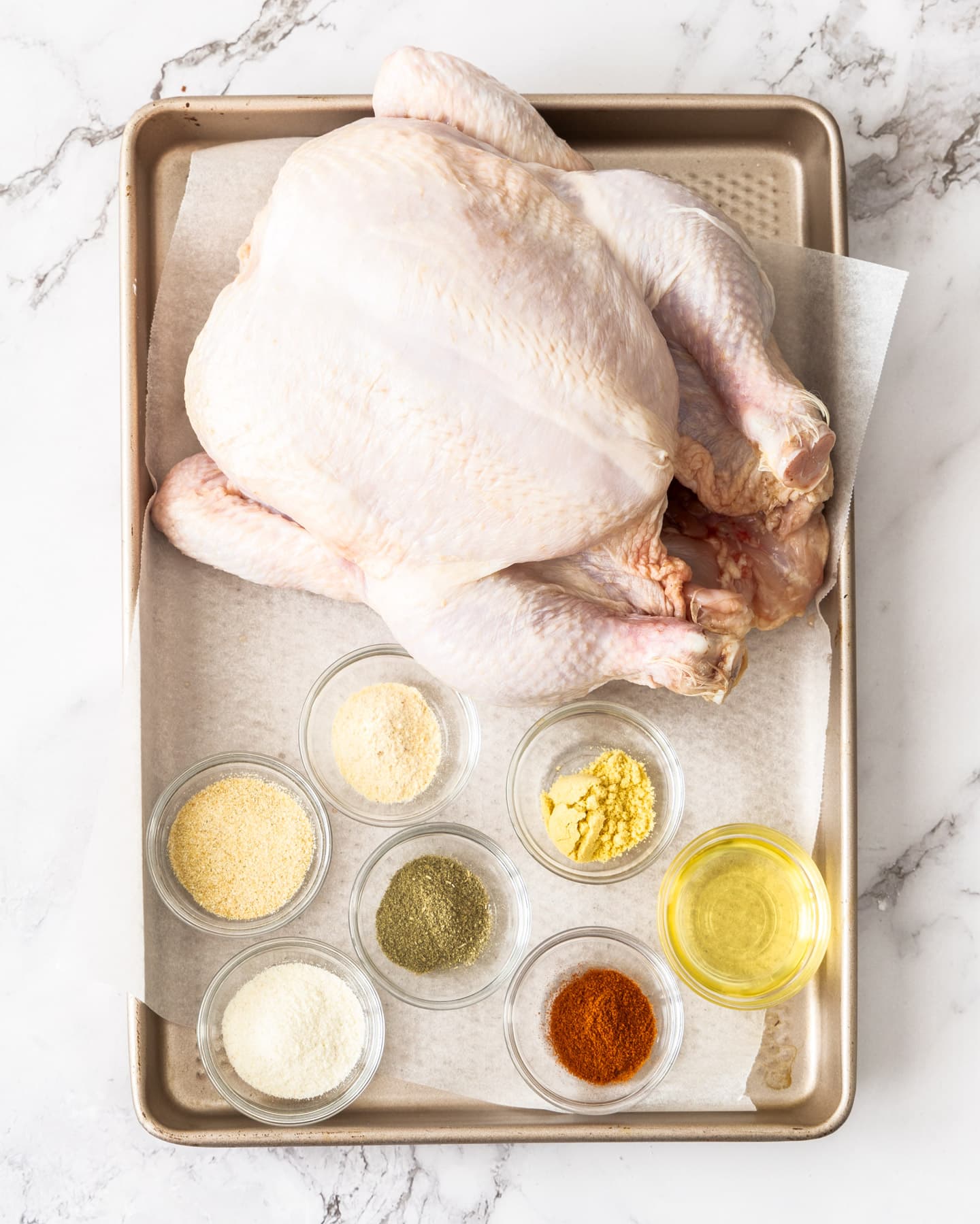 Ingredients for air fryer roast chicken on a baking tray.