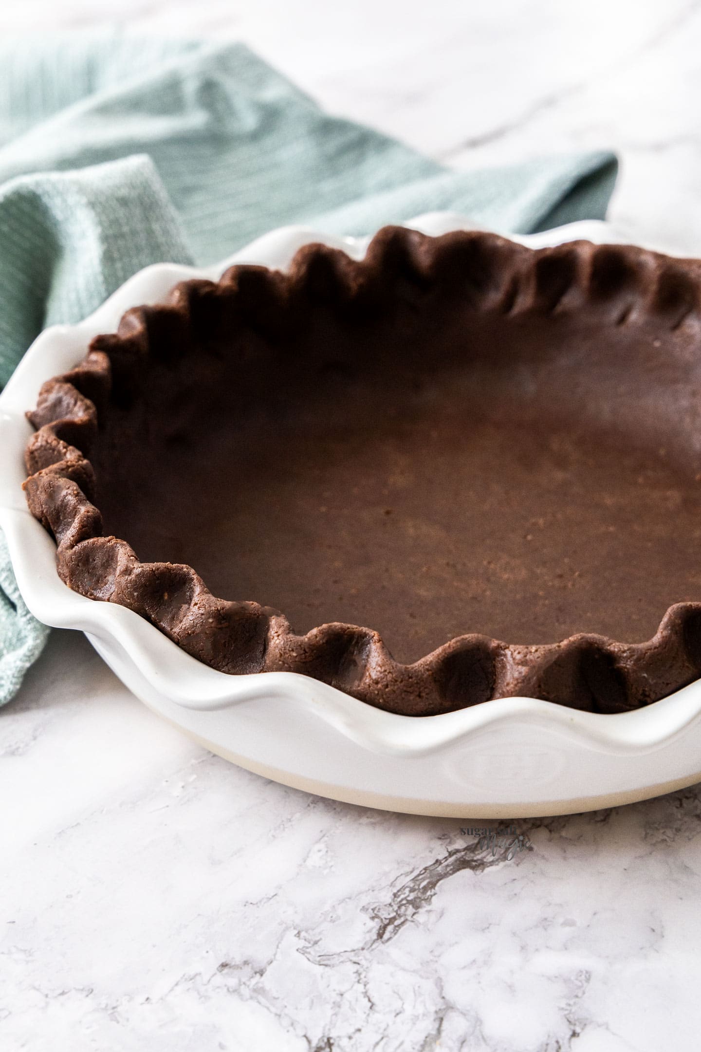 Chocolate pie crust, unbaked, shown at a 45 degree angle.