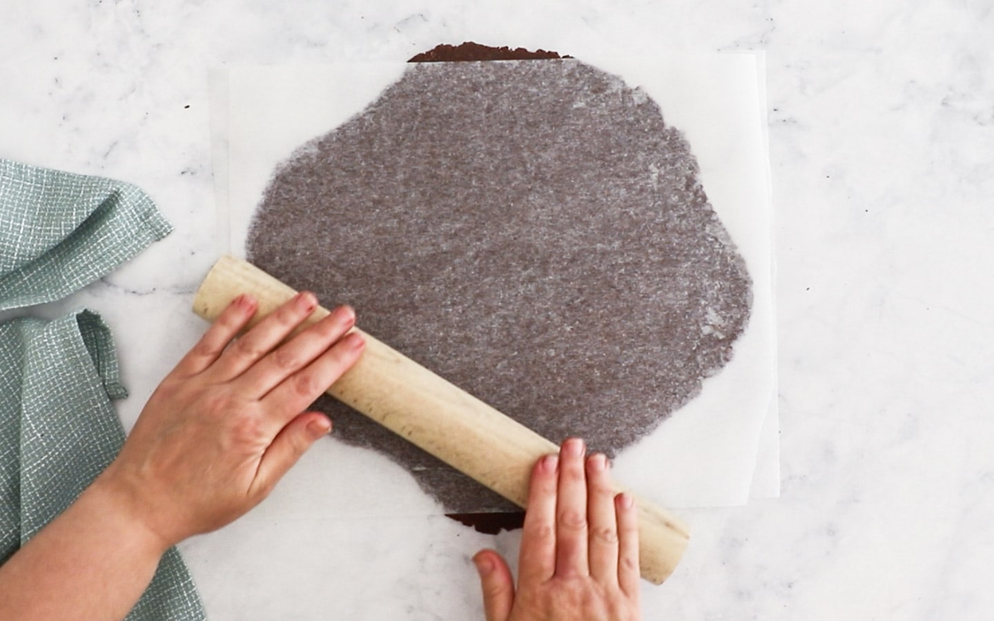 Rolling the chocolate pie dough out between two sheets of baking paper.