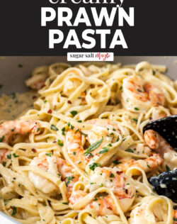 Linguine and prawns in a creamy sauce in a pan.