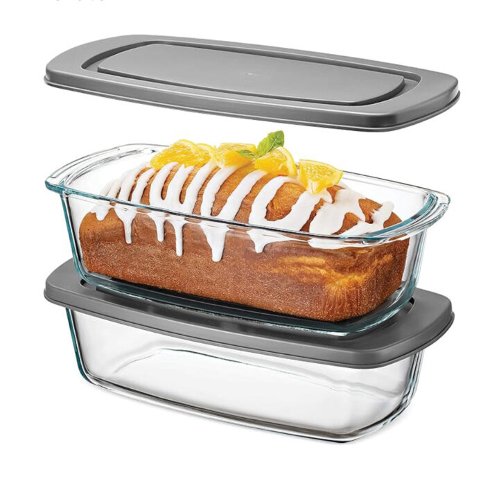 Two glass loaf pans with lids with a cake in one.