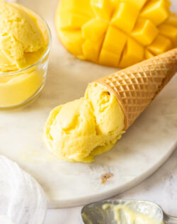 A waffle cone filled with mango gelato.