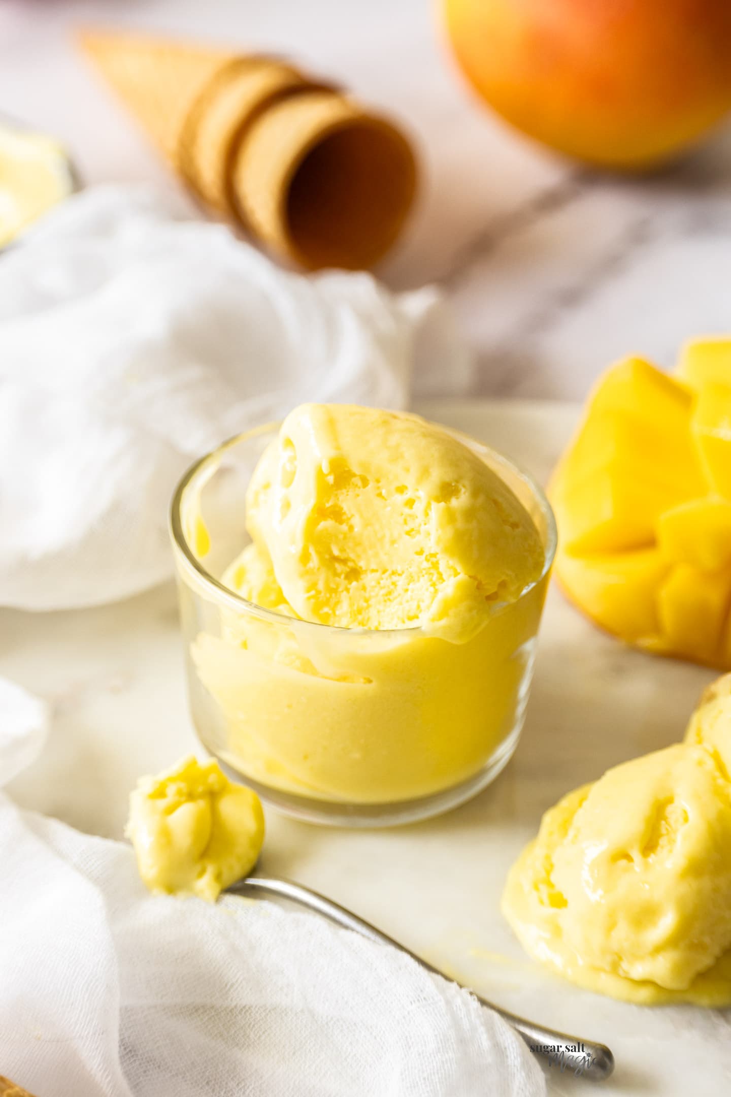 A small glass bowl filled with mango gelato.