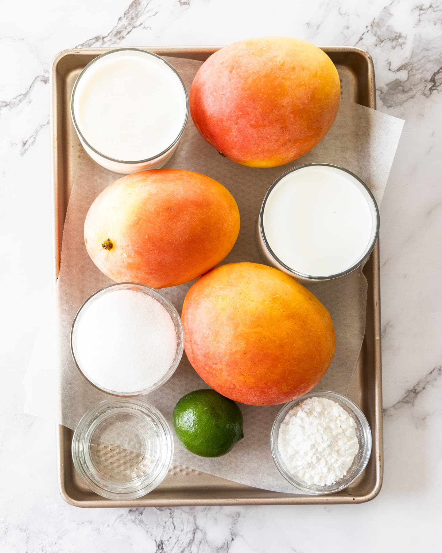 Ingredients for mango gelato on a baking tray.