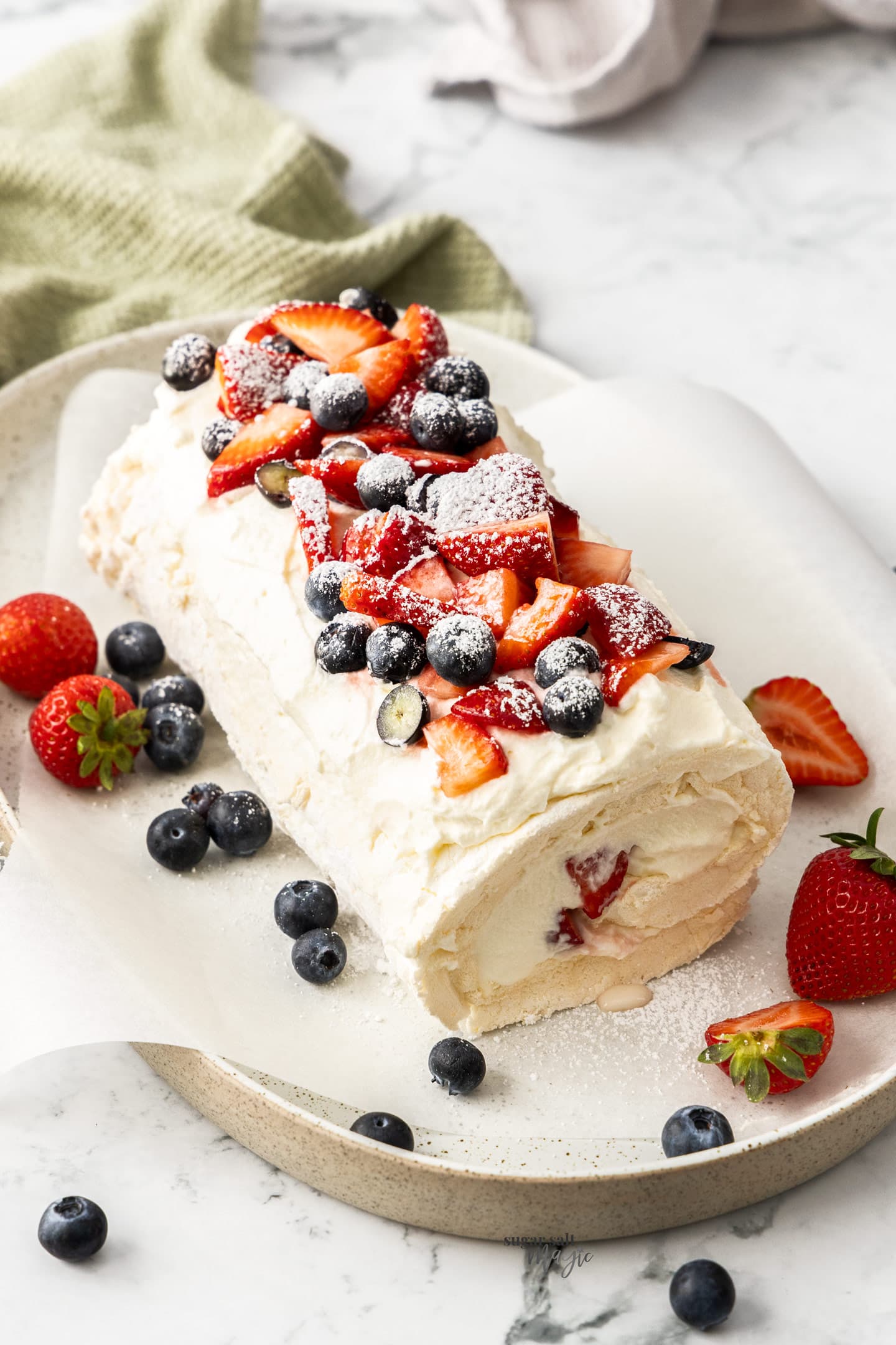 A meringue roulade on a long serving plate.