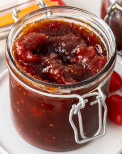 Closeup of a glass jar filled with tomato chilli jam.