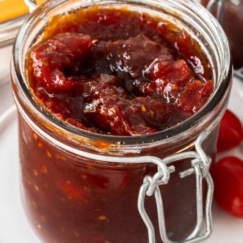 Closeup of a glass jar filled with tomato chilli jam.