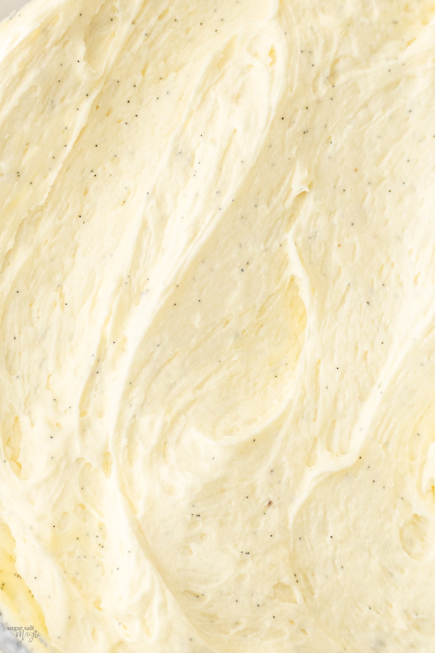 Closeup of swirls of vanilla bean frosting.