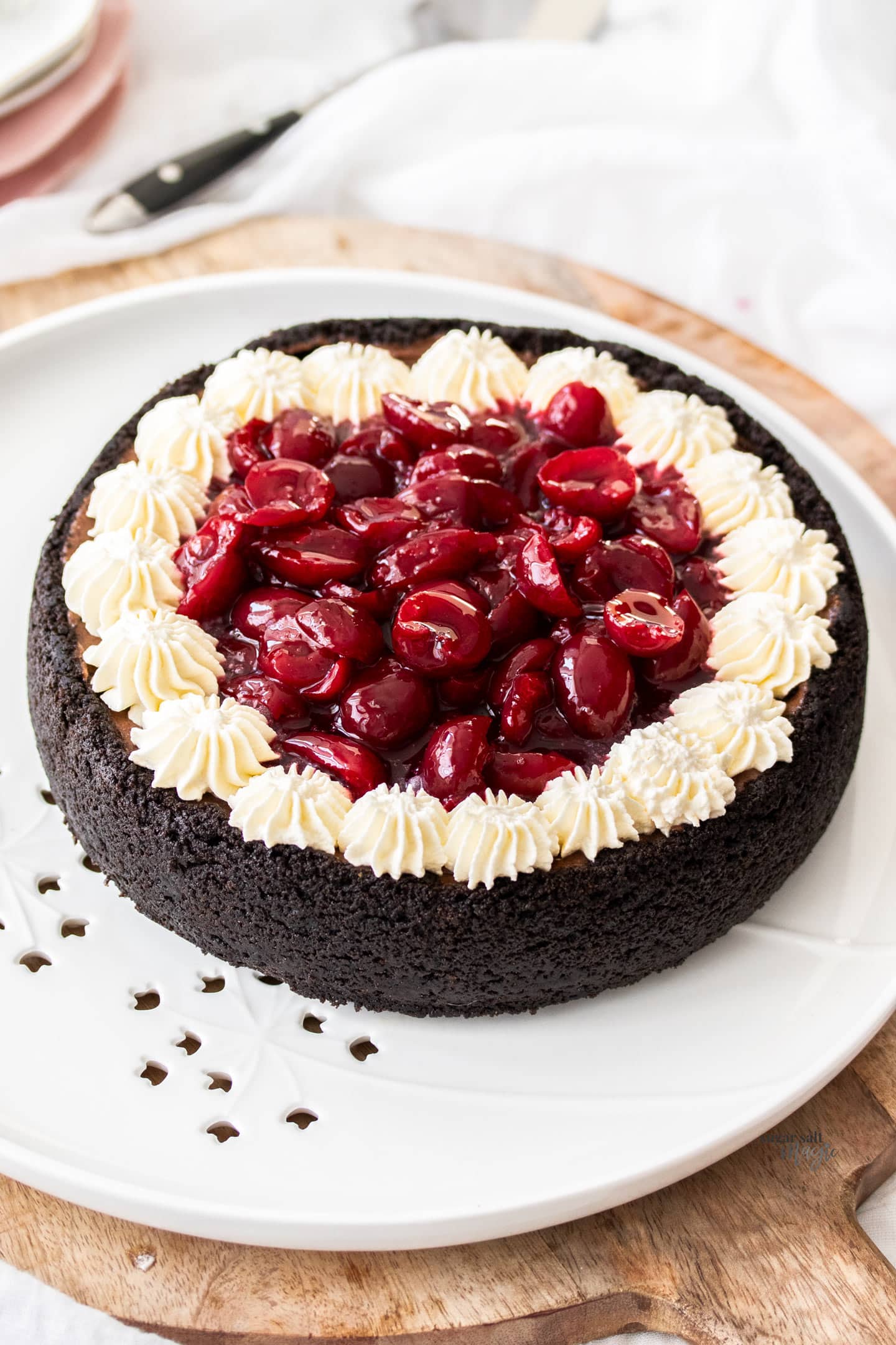 A whole black forest cheesecake on a platter.