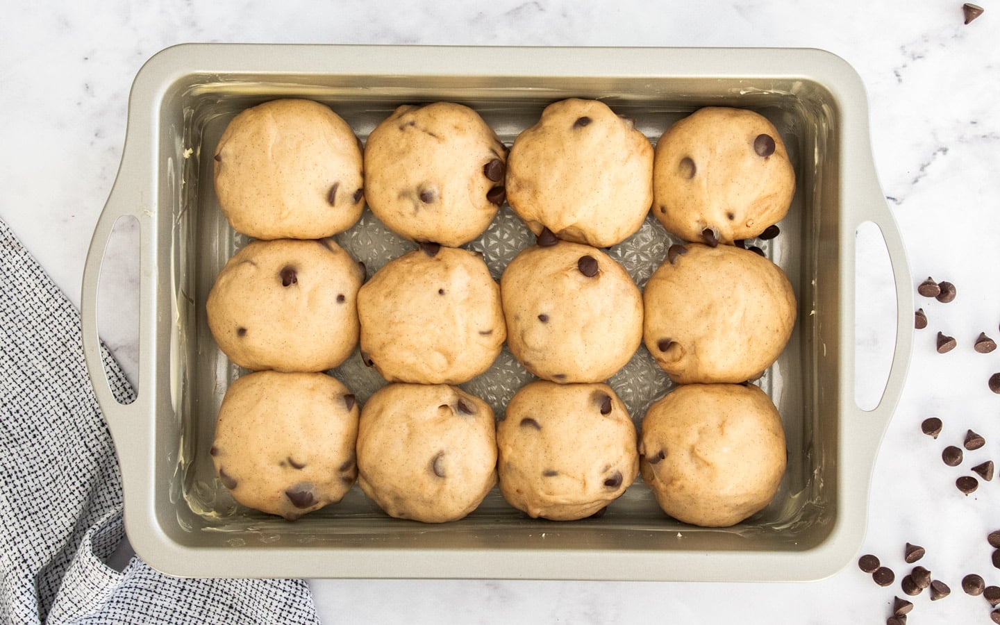 12 buns that have risen in a pan.