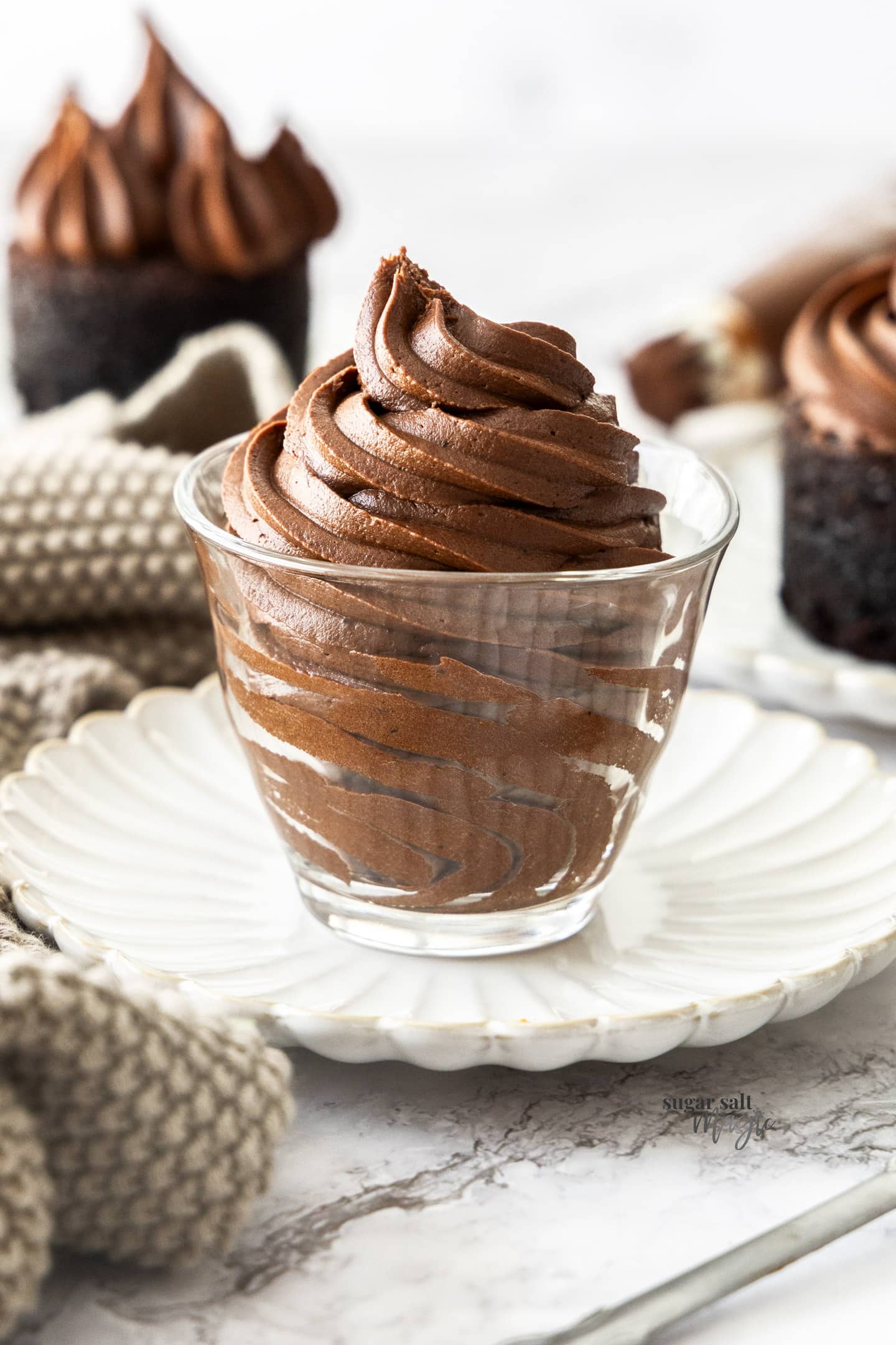 A glass filled with chocolate fudge frosting.
