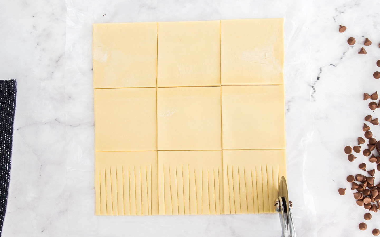 Showing how to cut the strands of puff pastry.