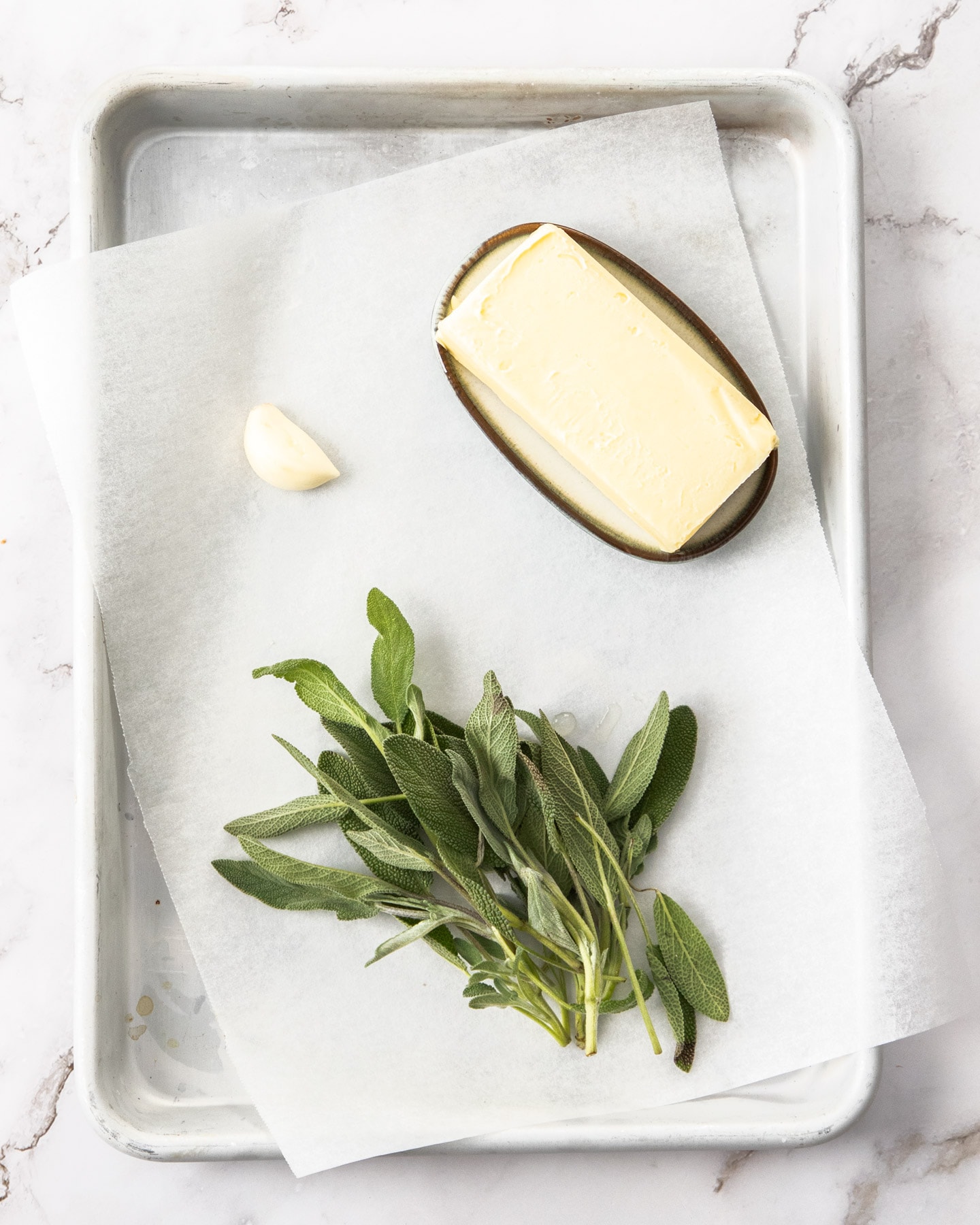 Ingredients for sage butter sauce on a baking tray.