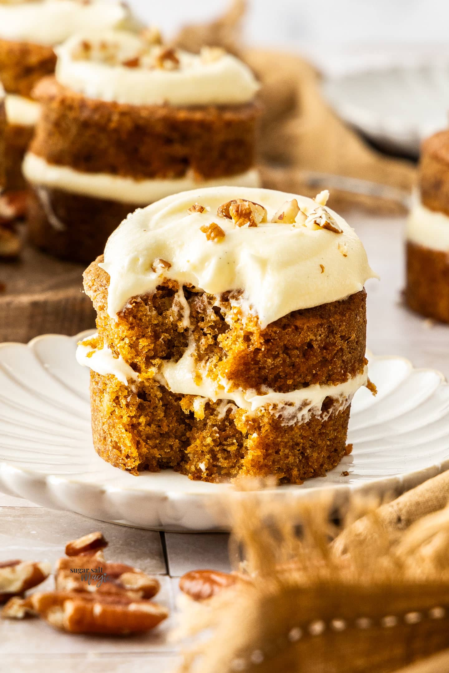 A mini carrot cake with a forkful cut out showing the fluffy texture.
