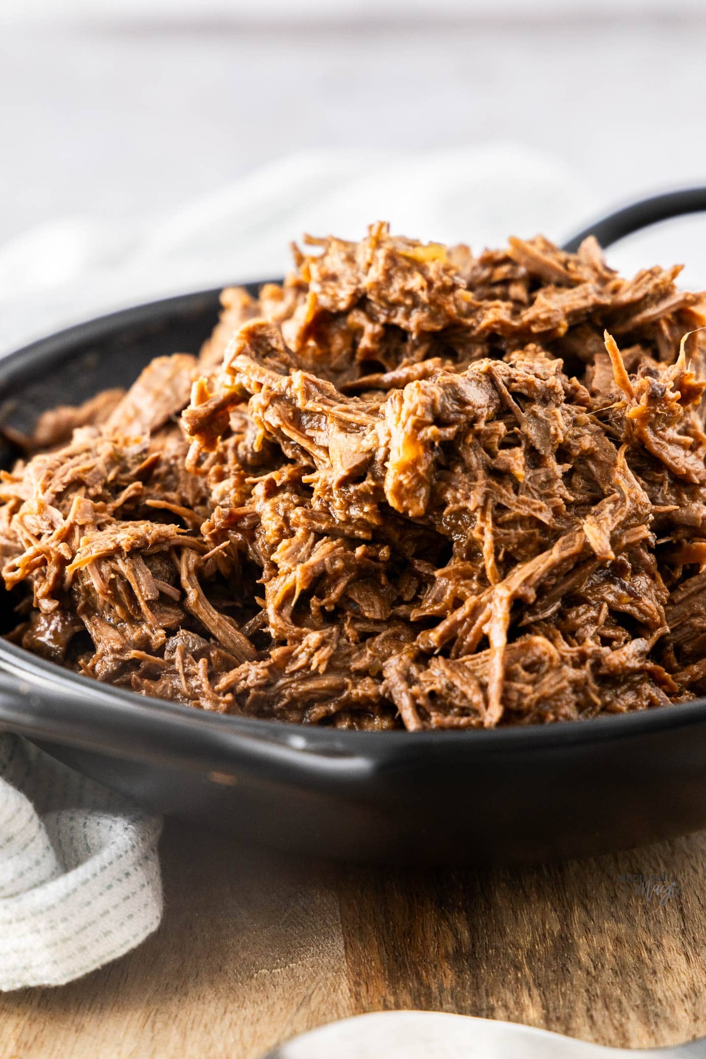 Pulled beef piled high in a black bowl.