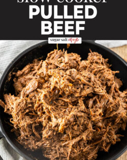 Slow cooked shredded beef in a black bowl.