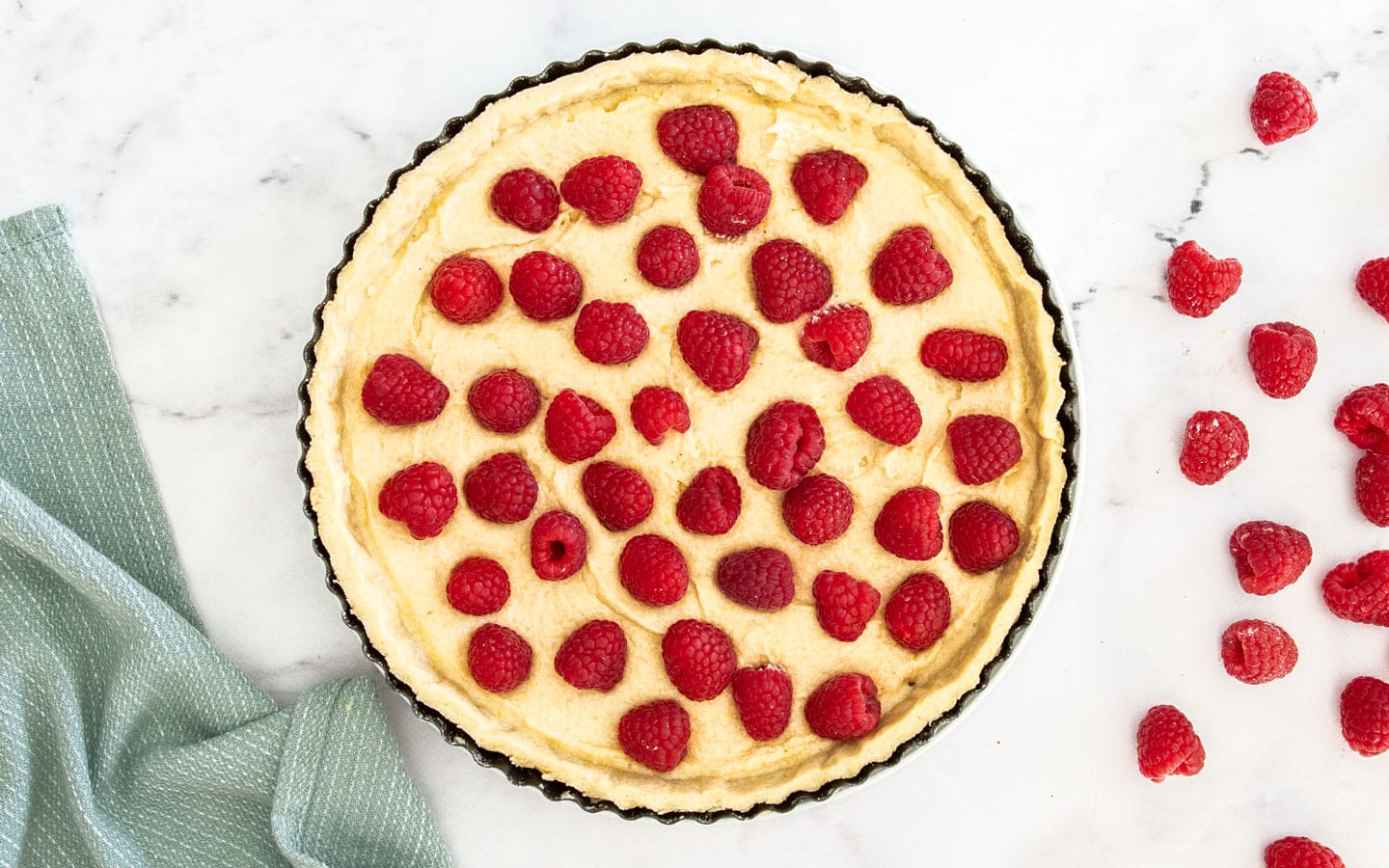 The tart shell filled with frangipane and raspberries.
