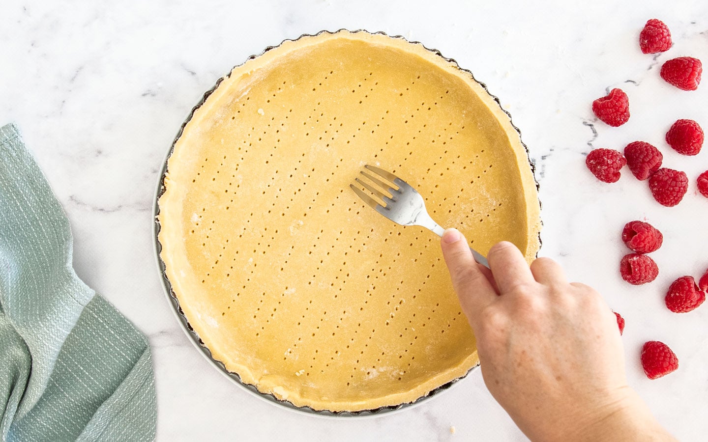 Docking the base of the tart shell with a fork.