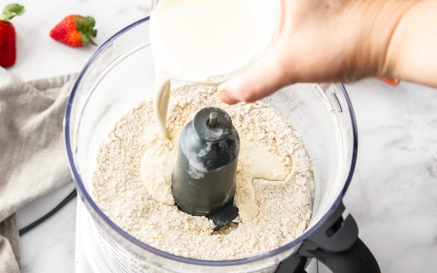 Adding cream to the dry ingredients.