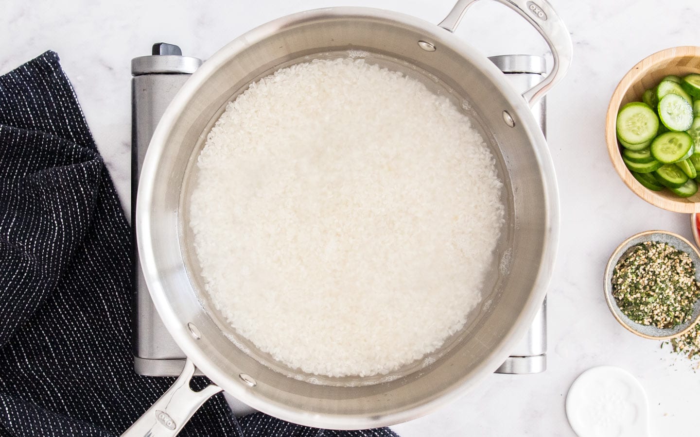 Rice covered by water in a saucepan.