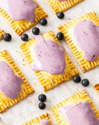 Top down view of blueberry pop tarts surrounded by fresh blueberries.