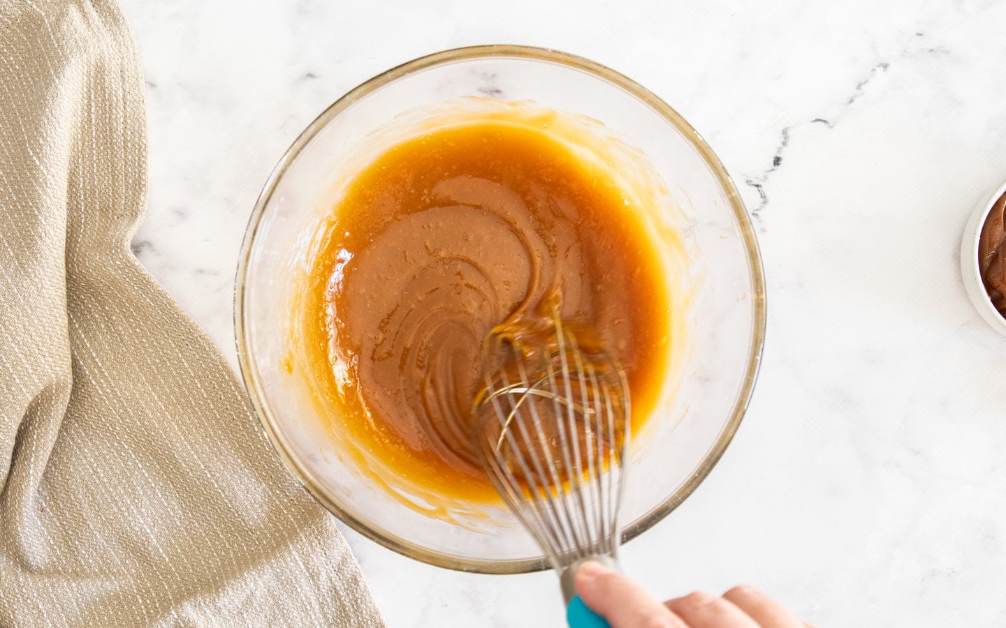 Whisking together caramel and eggs.