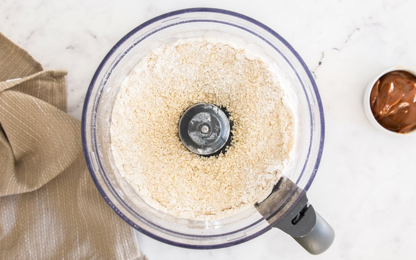The pastry mixture in the food processor after the egg is added.