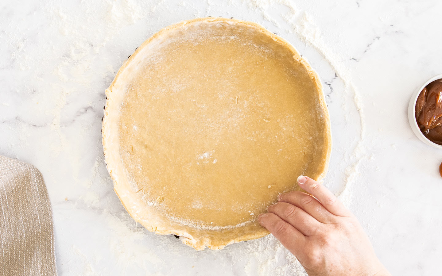 Pressing the pastry into the tart pan.