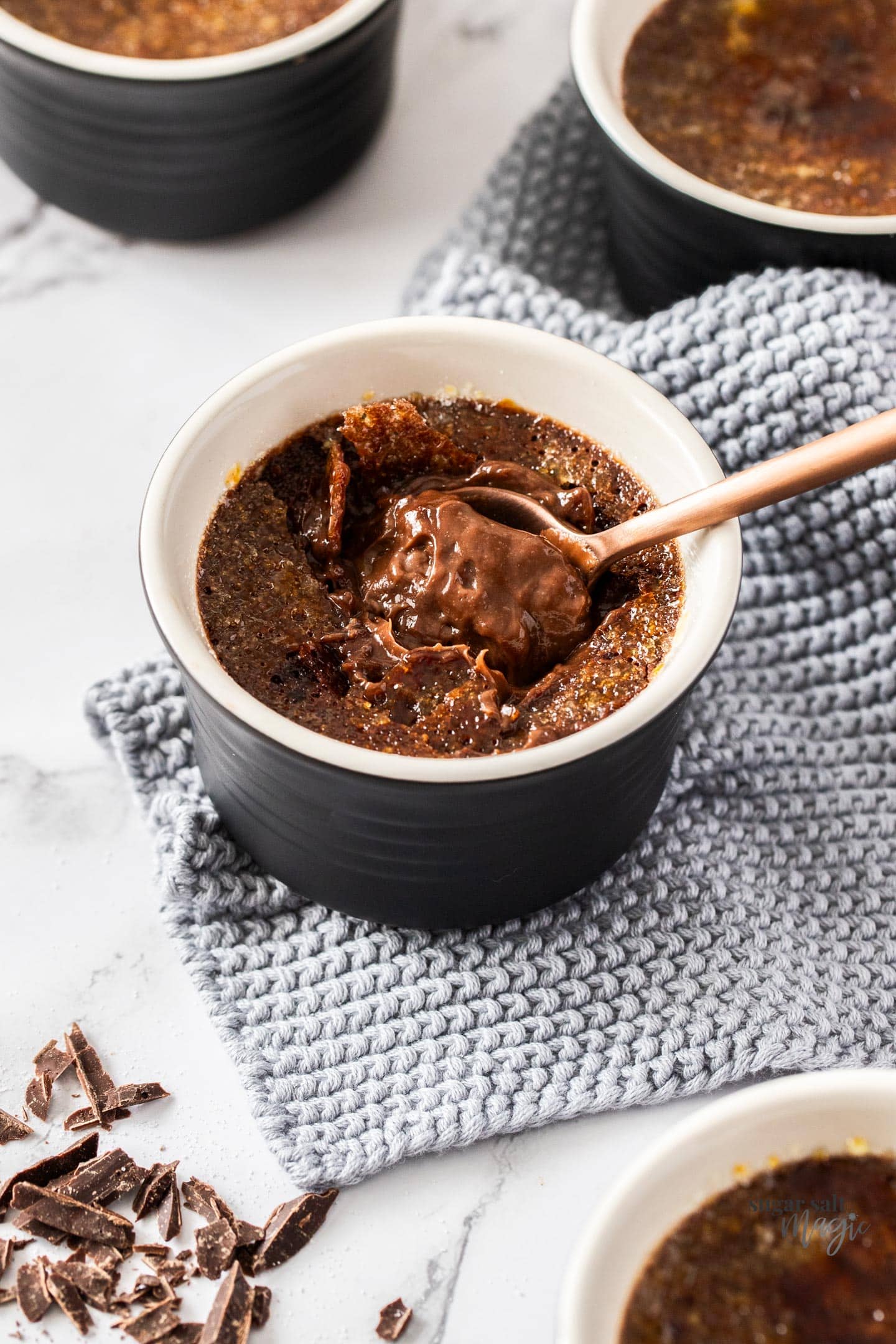 A spoon digging into chocolate creme brulee.