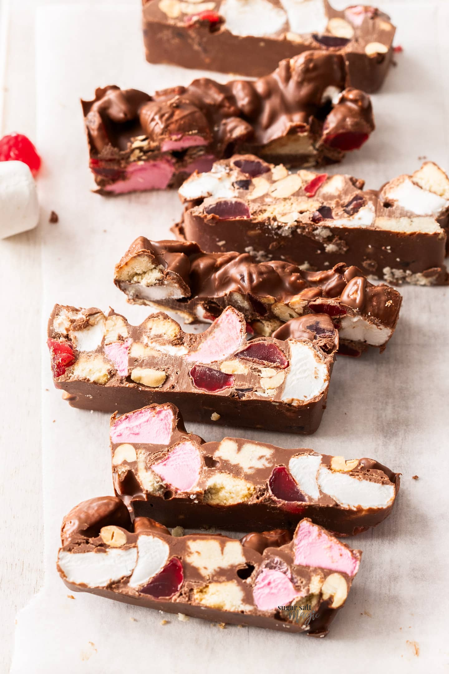 Slices of rocky road on a wooden board.