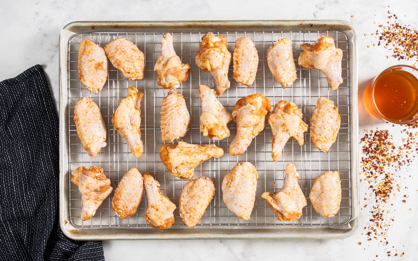 The seasoned wing pieces on a baking tray.