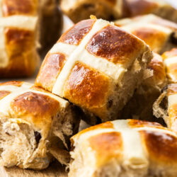 Closeup of a brioche hot cross bun turned on it's side to show the cross on top.